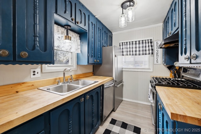 kitchen featuring pendant lighting, blue cabinetry, stainless steel appliances, a sink, and under cabinet range hood