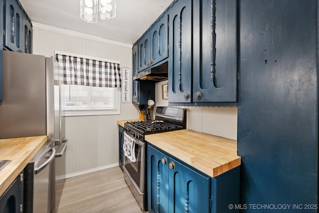 kitchen featuring appliances with stainless steel finishes, blue cabinets, wood counters, and light wood finished floors