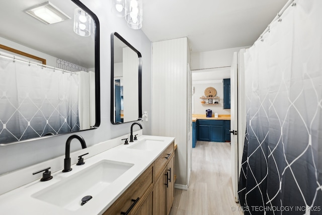 full bathroom with double vanity, wood finished floors, a sink, and visible vents