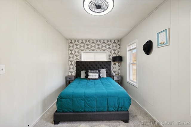 bedroom featuring light carpet and an accent wall