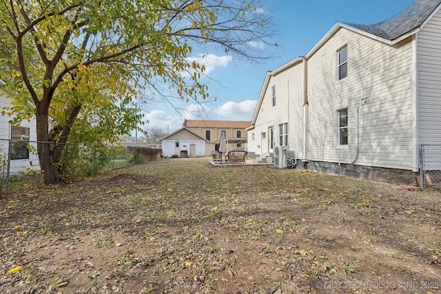 view of yard with central AC unit and fence