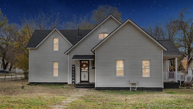 traditional home featuring a shingled roof and a front yard