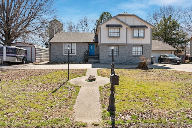 view of front of house featuring concrete driveway, stone siding, roof with shingles, and a front yard