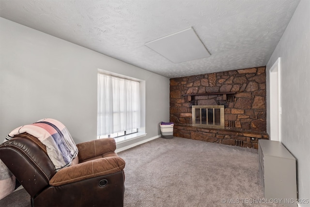 living room with a textured ceiling, a stone fireplace, carpet, and baseboards