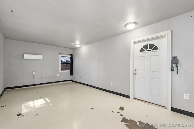 interior space with baseboards, a wall mounted AC, and finished concrete floors