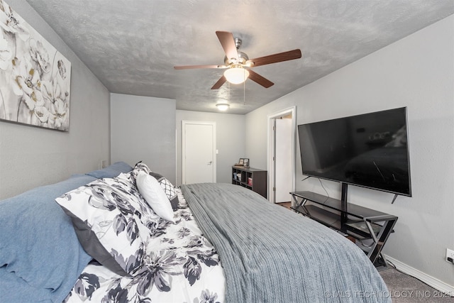 bedroom featuring a ceiling fan, a textured ceiling, and baseboards