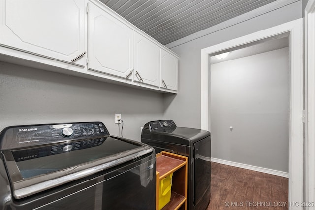 laundry room with dark wood-style floors, cabinet space, washer and clothes dryer, and baseboards