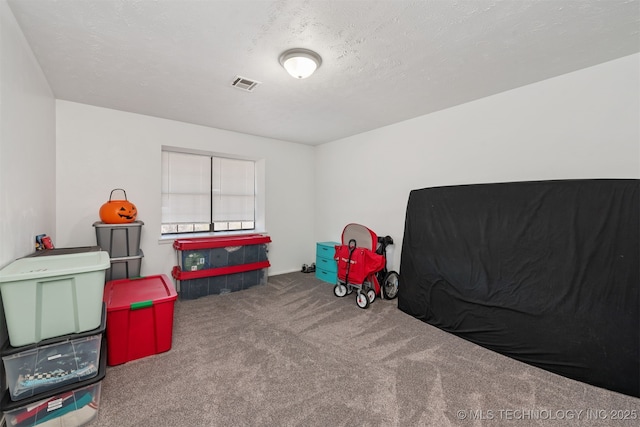 recreation room featuring a textured ceiling, carpet, and visible vents