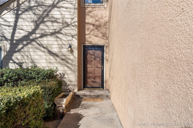 entrance to property featuring stucco siding