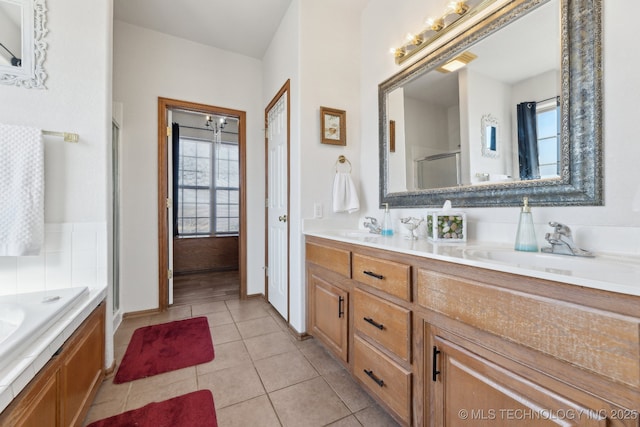 bathroom featuring a sink, a bath, tile patterned floors, double vanity, and a stall shower