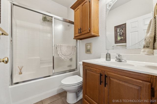 bathroom featuring toilet, tile patterned flooring, enclosed tub / shower combo, and vanity