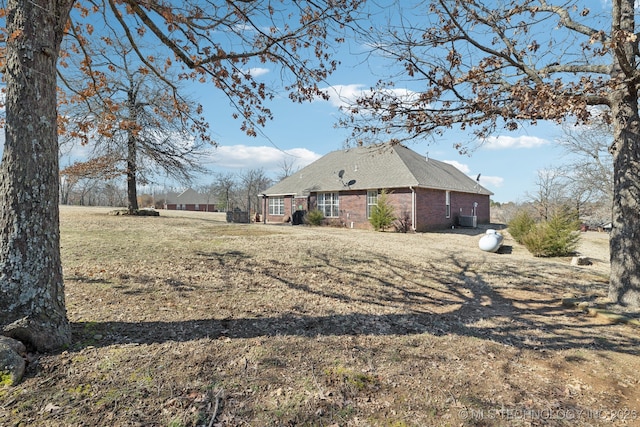 view of home's exterior featuring brick siding and a lawn