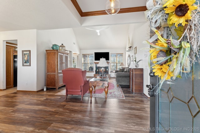 living area with lofted ceiling, baseboards, dark wood finished floors, and ornamental molding