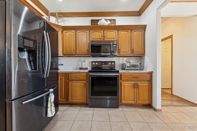 kitchen featuring stainless steel appliances, brown cabinets, and backsplash