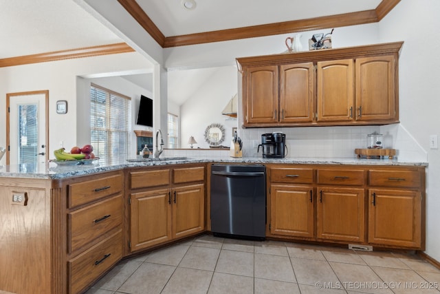 kitchen with a peninsula, a sink, light stone countertops, and brown cabinets