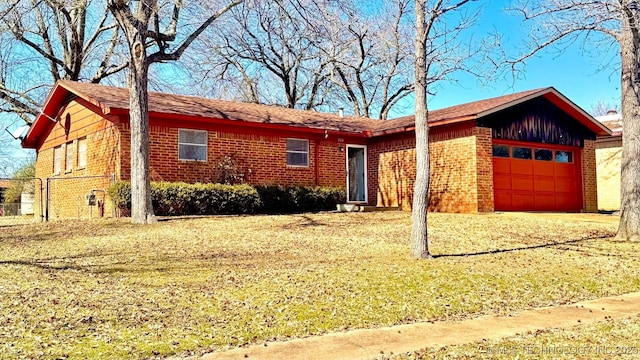 single story home featuring a front lawn, brick siding, and an attached garage