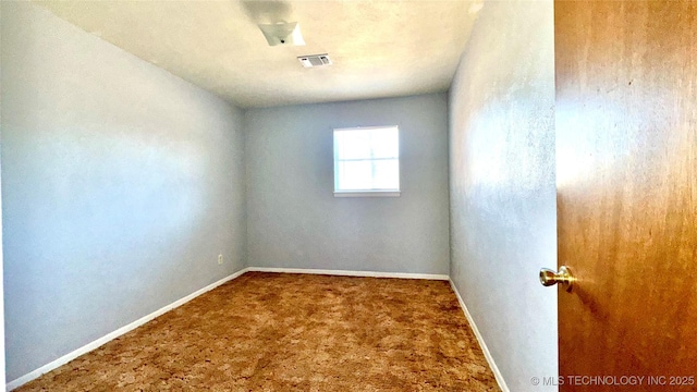 carpeted spare room featuring visible vents and baseboards