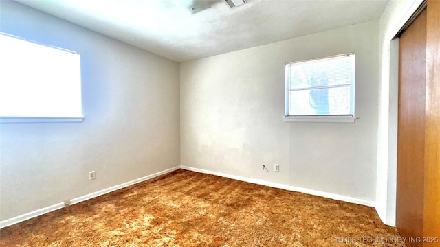 unfurnished room featuring baseboards and dark carpet