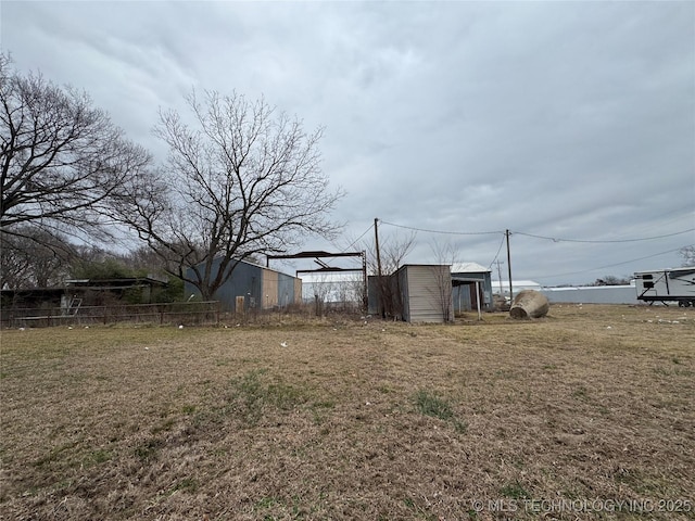 view of yard with an outdoor structure and fence