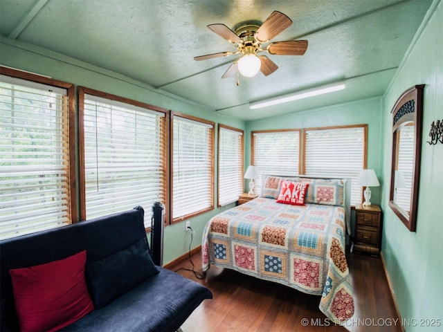 bedroom with lofted ceiling, dark wood-type flooring, a ceiling fan, a textured ceiling, and baseboards