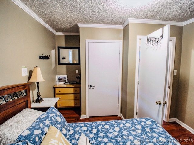 bedroom featuring ornamental molding, dark wood finished floors, and a textured ceiling