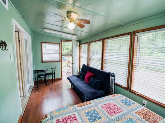 bedroom with baseboards, visible vents, dark wood-style floors, ceiling fan, and a textured ceiling