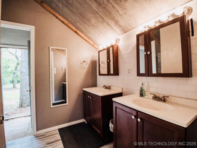 bathroom with vaulted ceiling, wood finished floors, two vanities, and a sink