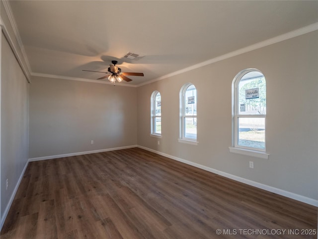 spare room with dark wood-style floors, baseboards, and ornamental molding