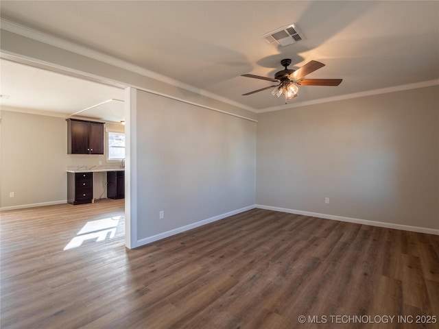 unfurnished room with dark wood-style flooring, visible vents, ornamental molding, a ceiling fan, and baseboards