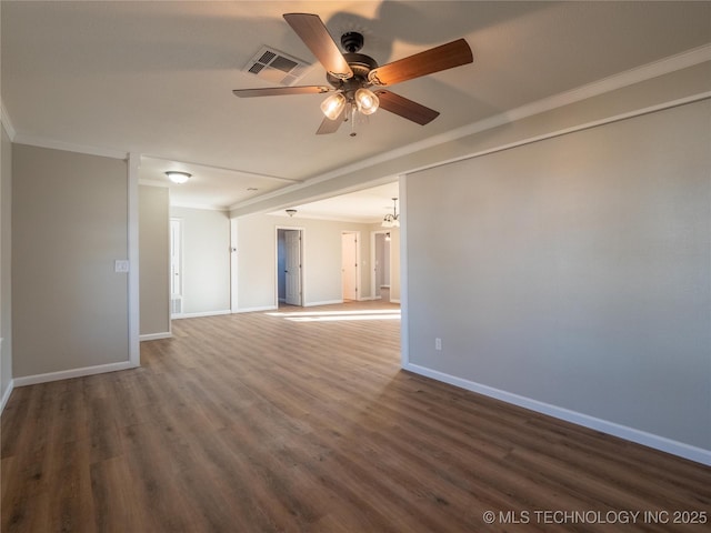 empty room with ornamental molding, dark wood-type flooring, visible vents, and baseboards