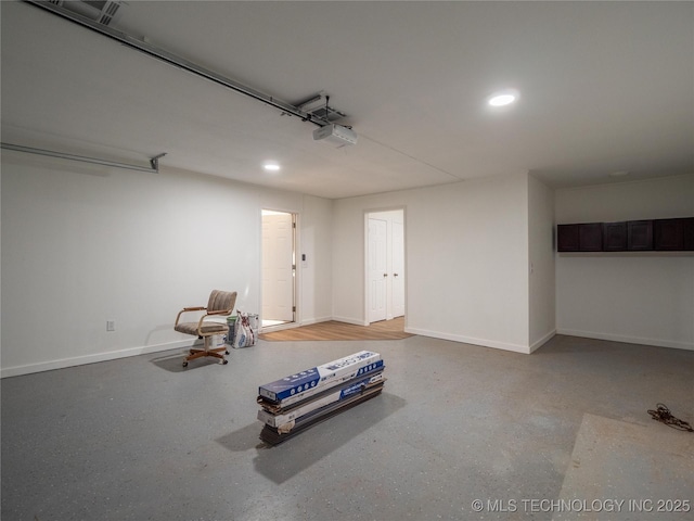 unfurnished room with a garage, recessed lighting, baseboards, and speckled floor