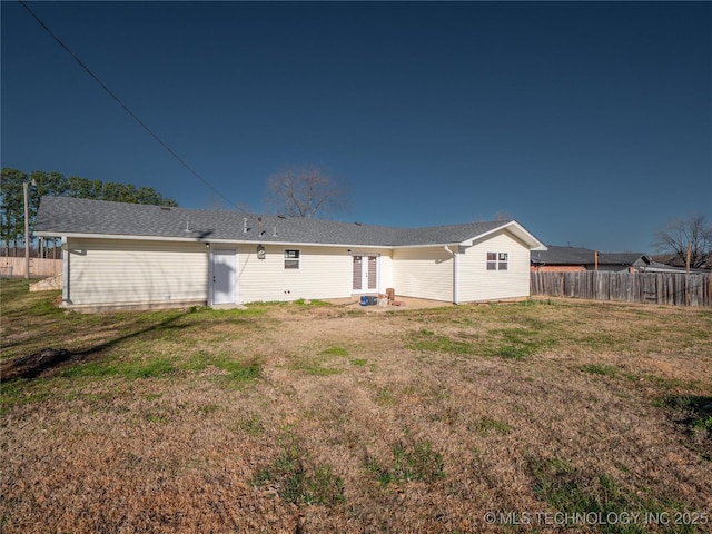 back of property featuring a yard and fence