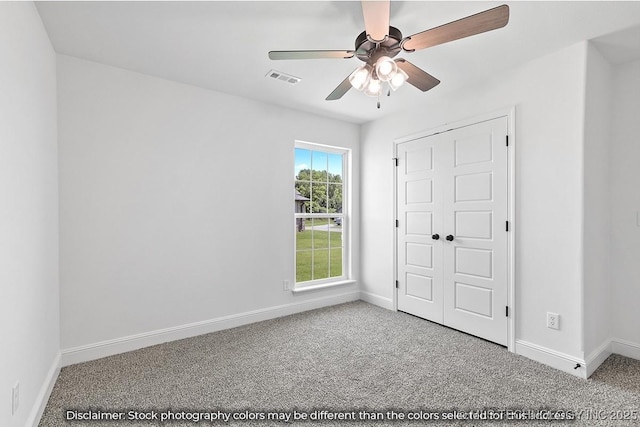 unfurnished bedroom with baseboards, visible vents, ceiling fan, and carpet flooring