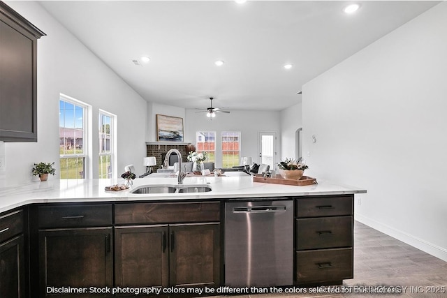 kitchen featuring dishwasher, light countertops, a peninsula, and a sink