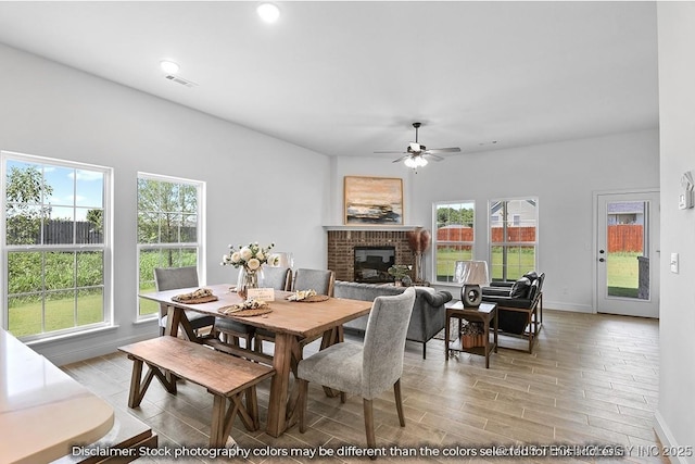 27983 E 109th St S, Coweta, OK 74014 - dining area featuring a fireplace, visible vents, wood tiled floor, ceiling fan, and baseboards