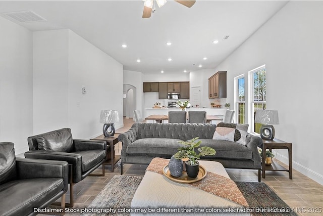 living room featuring arched walkways, recessed lighting, wood finish floors, visible vents, and baseboards