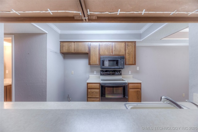 kitchen featuring light countertops, ornamental molding, brown cabinetry, a sink, and black appliances