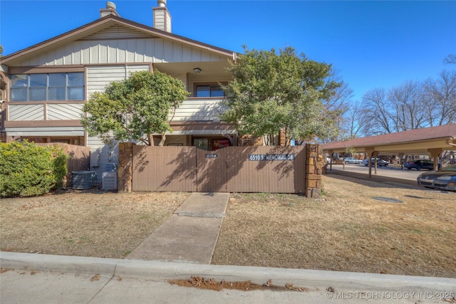 view of front of home with a fenced front yard, a chimney, and central air condition unit