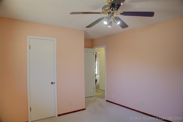 unfurnished bedroom with ceiling fan, baseboards, and light colored carpet