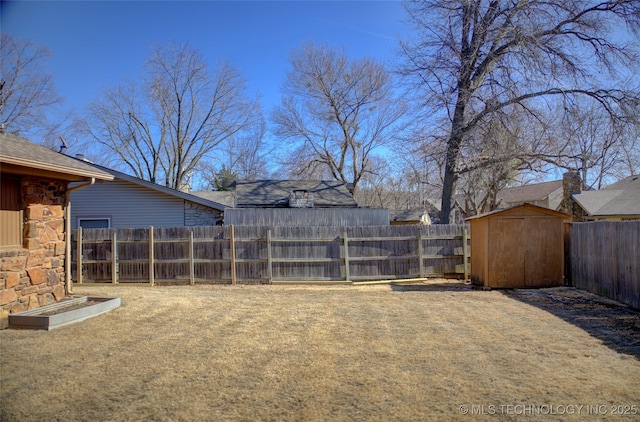 view of yard with an outbuilding, a storage unit, and a fenced backyard