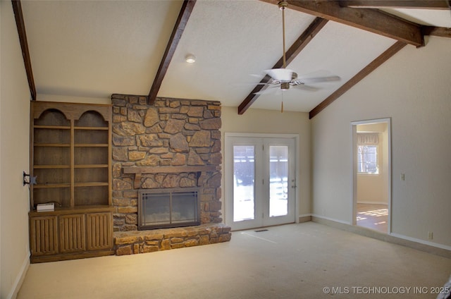 unfurnished living room with a healthy amount of sunlight, a fireplace, lofted ceiling with beams, and carpet flooring