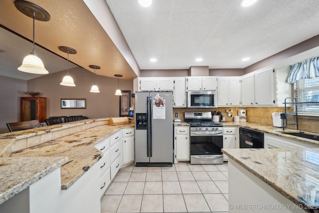 kitchen featuring light stone counters, stainless steel appliances, a peninsula, white cabinetry, and backsplash