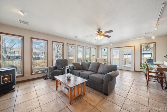 living room with visible vents, a textured ceiling, and french doors