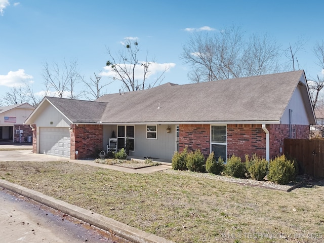 ranch-style home featuring driveway, roof with shingles, an attached garage, a front lawn, and brick siding