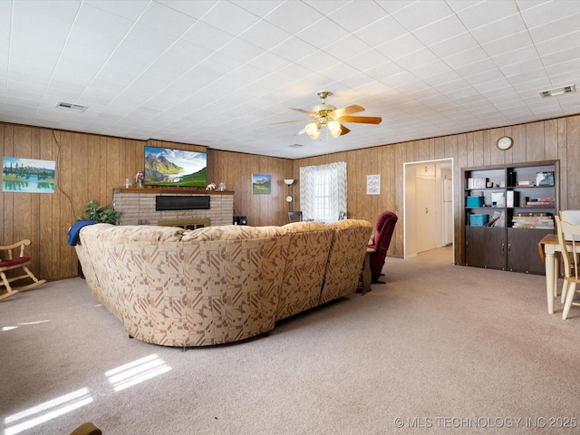 living area featuring a brick fireplace, visible vents, and light colored carpet