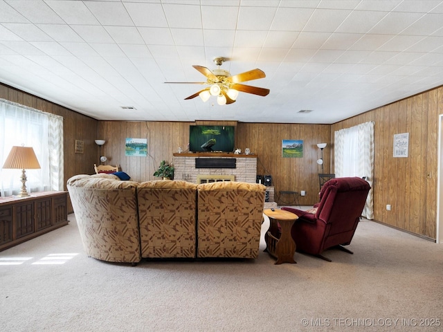 453576 Kaw Ave, Afton, OK 74331 - living room featuring ceiling fan, carpet flooring, wood walls, and a brick fireplace
