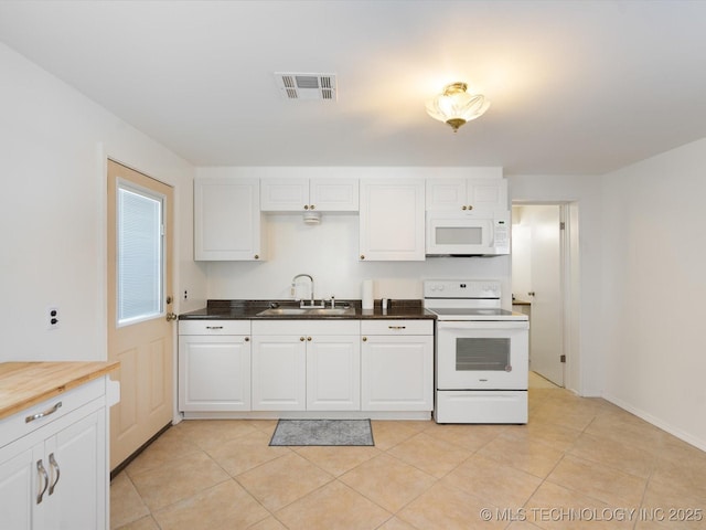 kitchen featuring white appliances, visible vents, white cabinets, butcher block countertops, and a sink