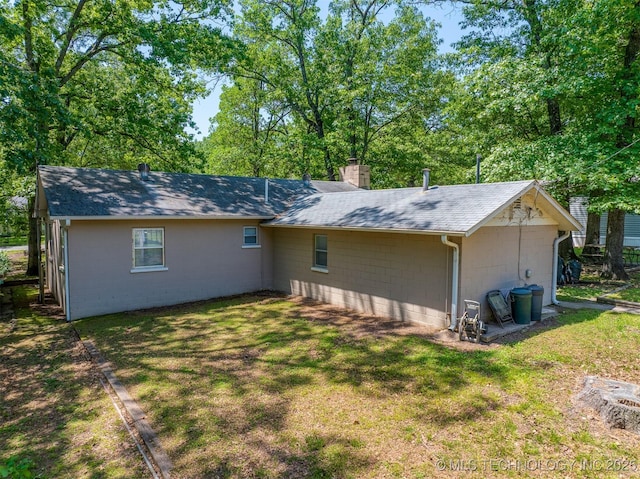 453576 Kaw Ave, Afton, OK 74331 - rear view of property with concrete block siding, a chimney, a lawn, and a shingled roof