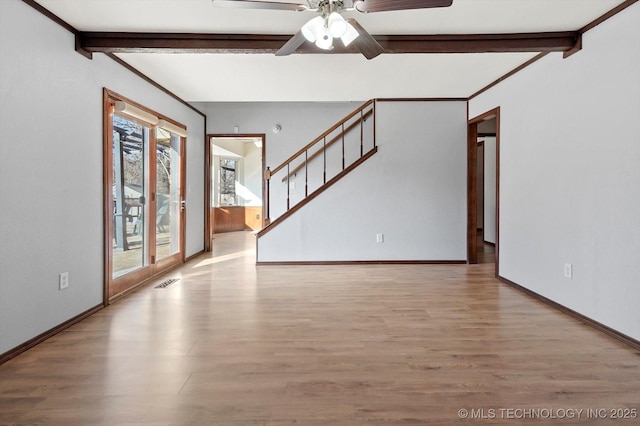 interior space featuring stairway, light wood-type flooring, and beam ceiling