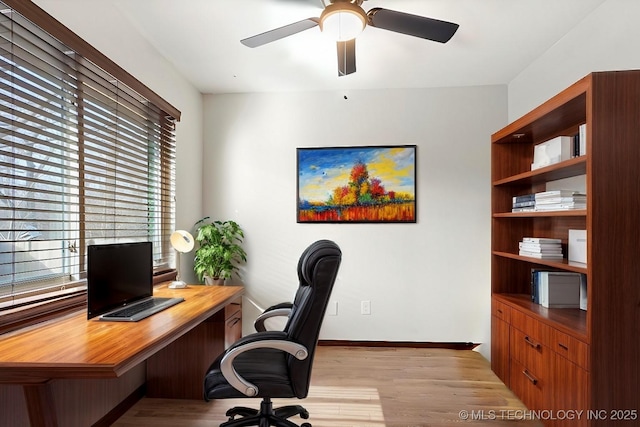 office featuring light wood-style floors, ceiling fan, and baseboards